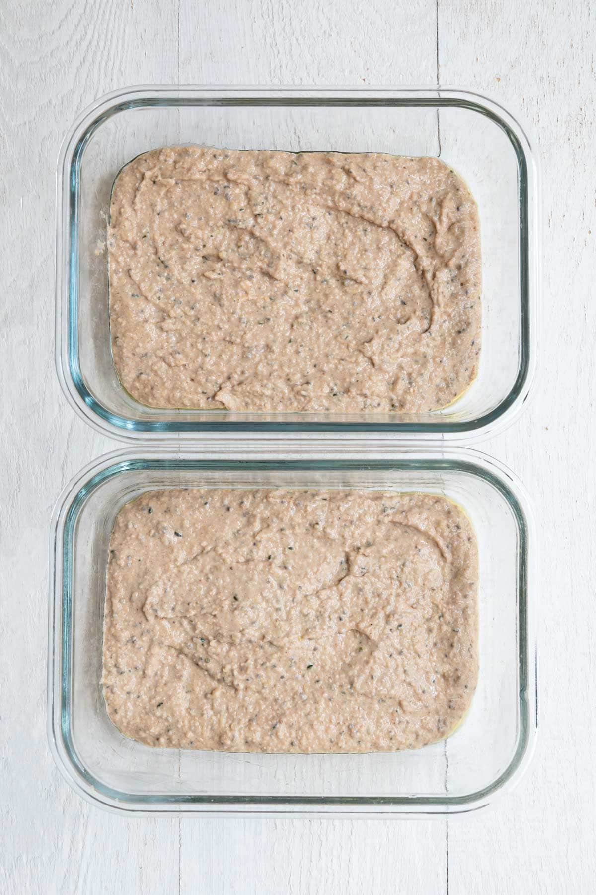 Healthy high-protein banana loaf batter with yogurt in two baking dishes.