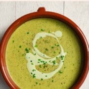 Vegan broccoli soup topped with tofu cream and chopped chives.