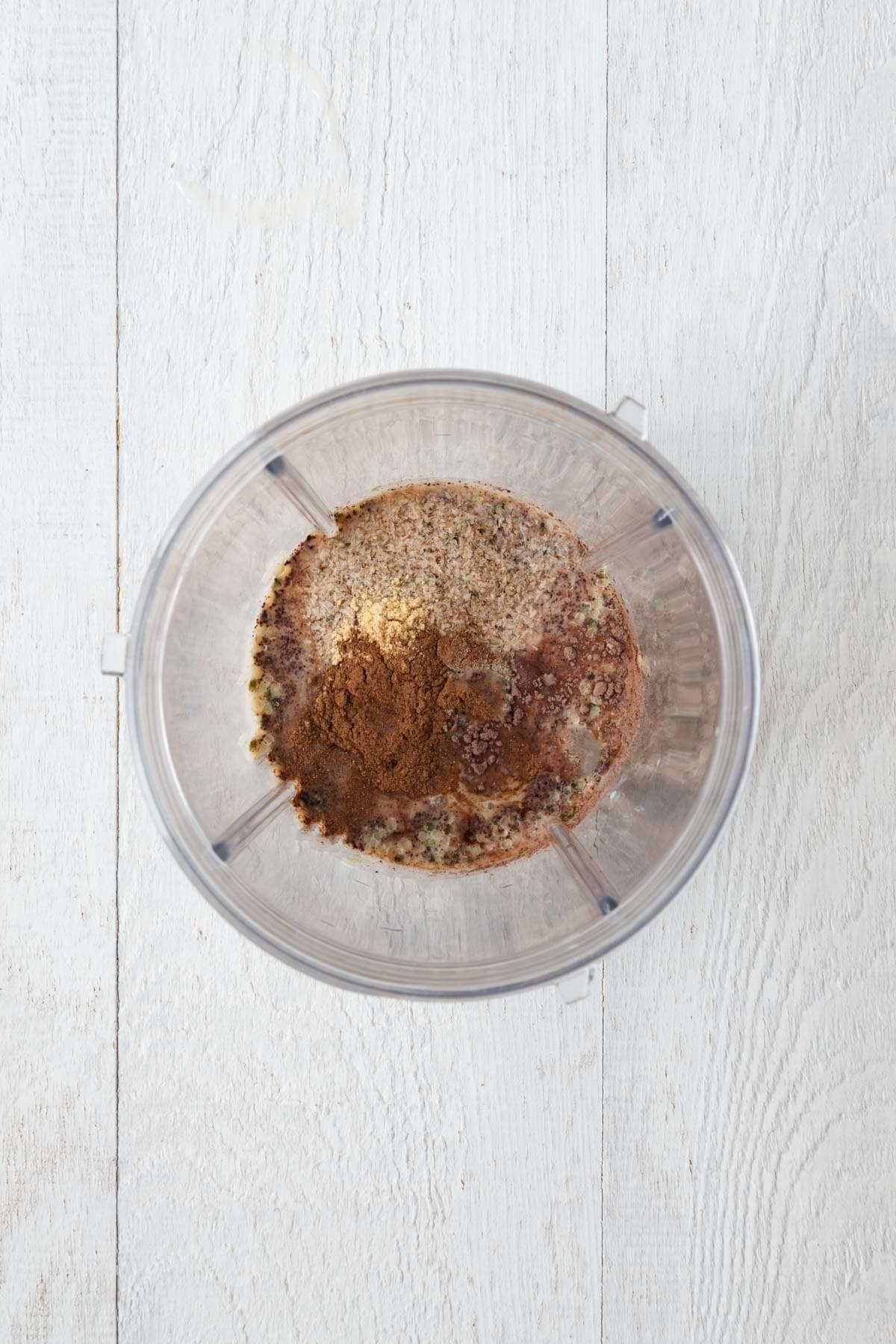 Nondairy milk, hemp hearts, vanilla extract, psyllium husk, vanilla extract, ground ginger, cardamom, and cinnamon, tapioca starch, cocoa powder, and dates in a blender.