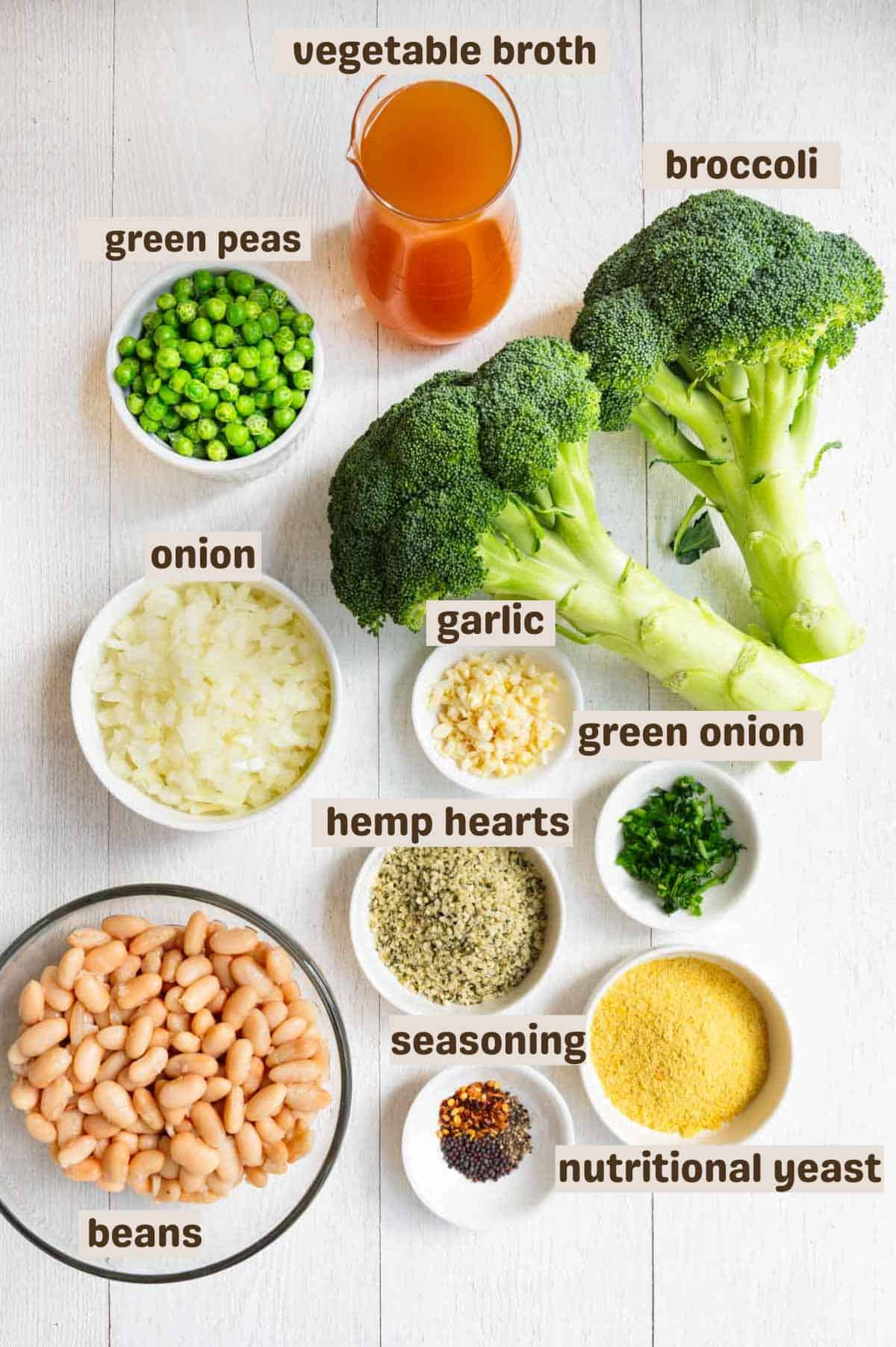 Vegetable broth, sliced broccoli stems, broccoli florets, white beans, green peas, hemp hearts, nutritional yeast, and seasoning in a large saucepan.