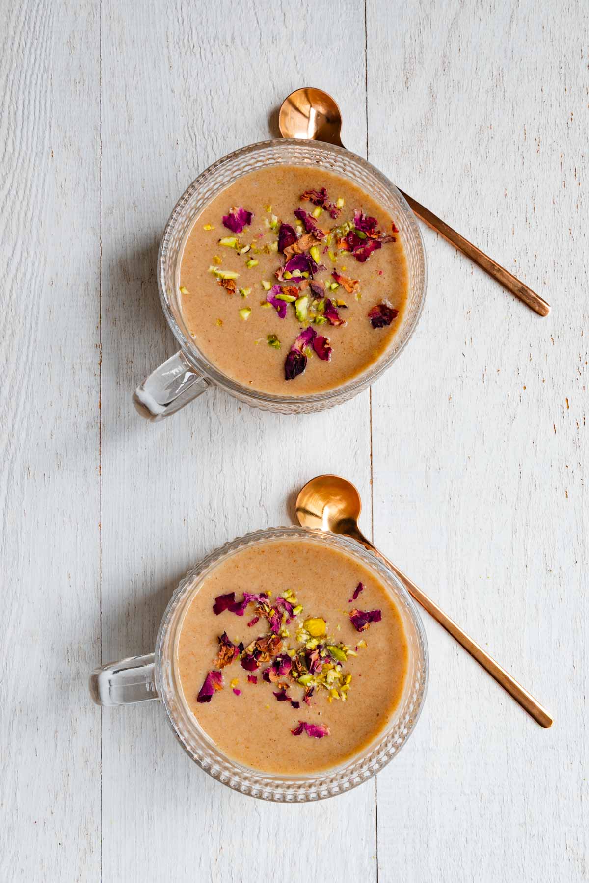 Easy protein chai latte naturally sweetened with dates topped with rose petals and chopped pistachios.