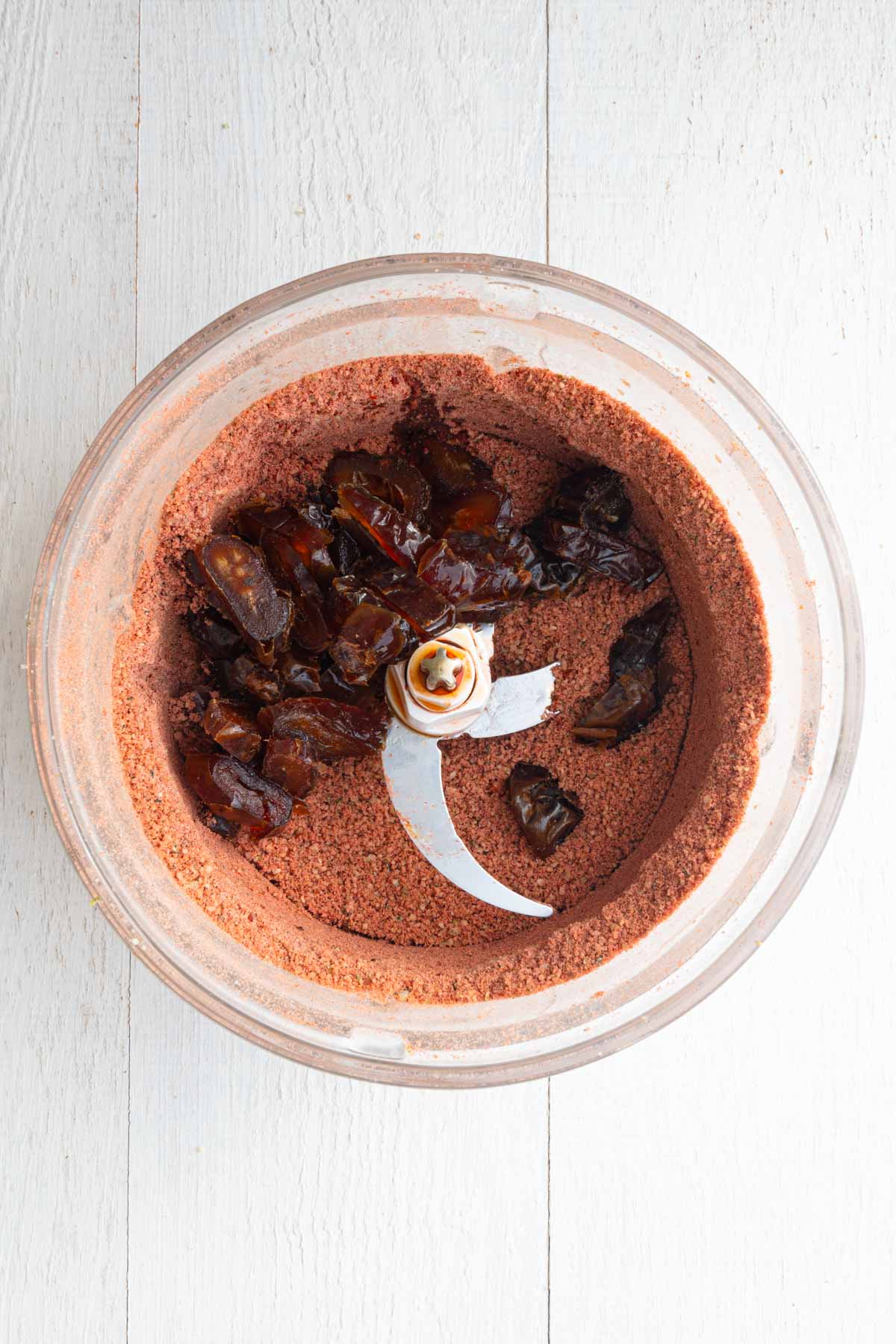 Processed walnuts, pumpkin seeds, protein powder, hemp hearts, beet powder and cinnamon in a food processor with vanilla and chopped dates.