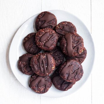 Twelve no-bake protein cookies on a white plate.