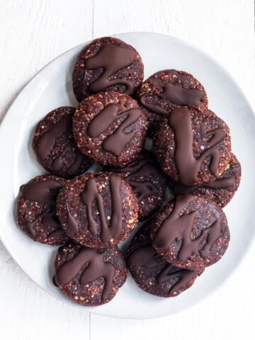 Twelve no-bake protein cookies on a white plate.