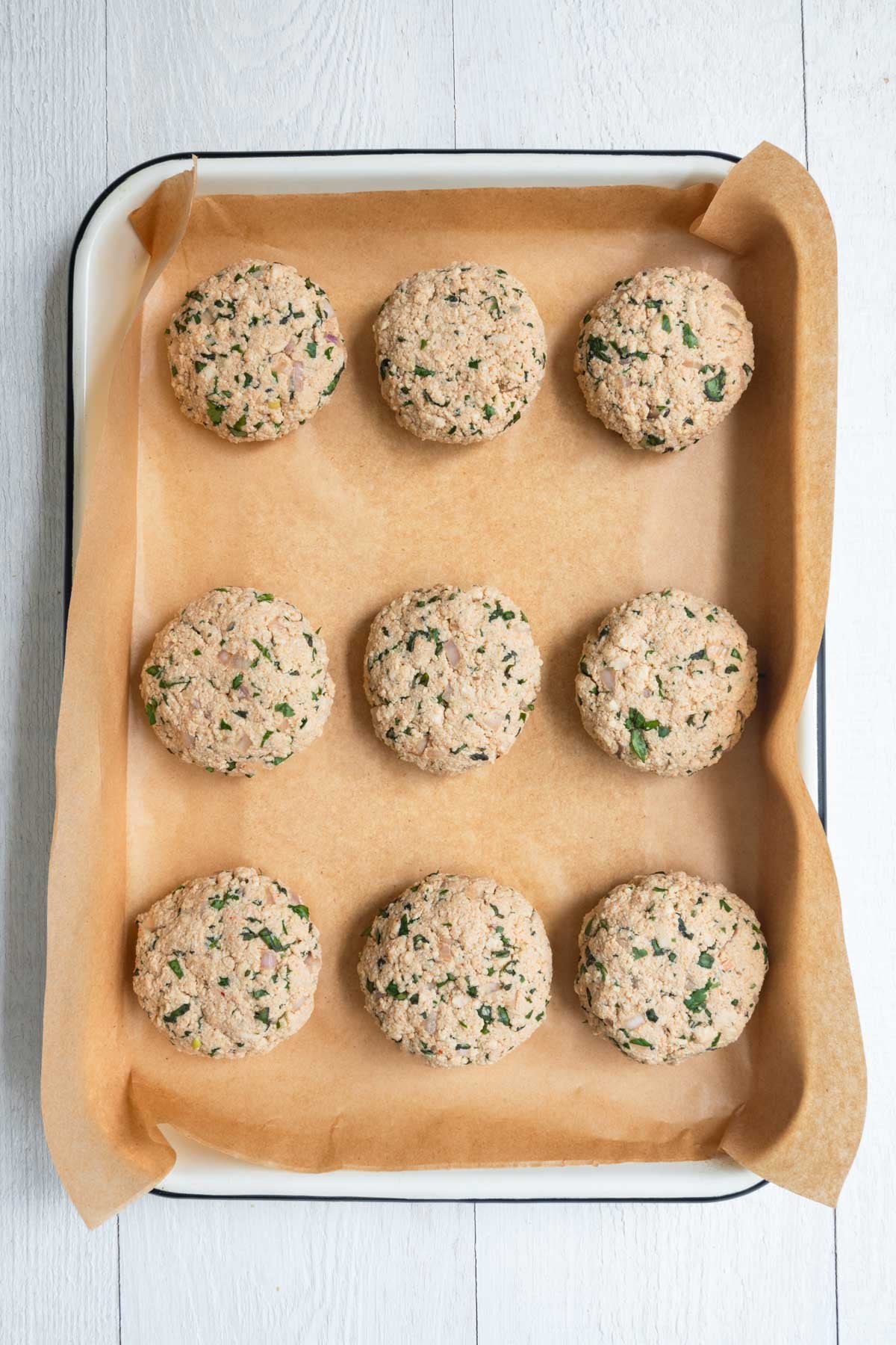 Nine patties on a baking sheet.
