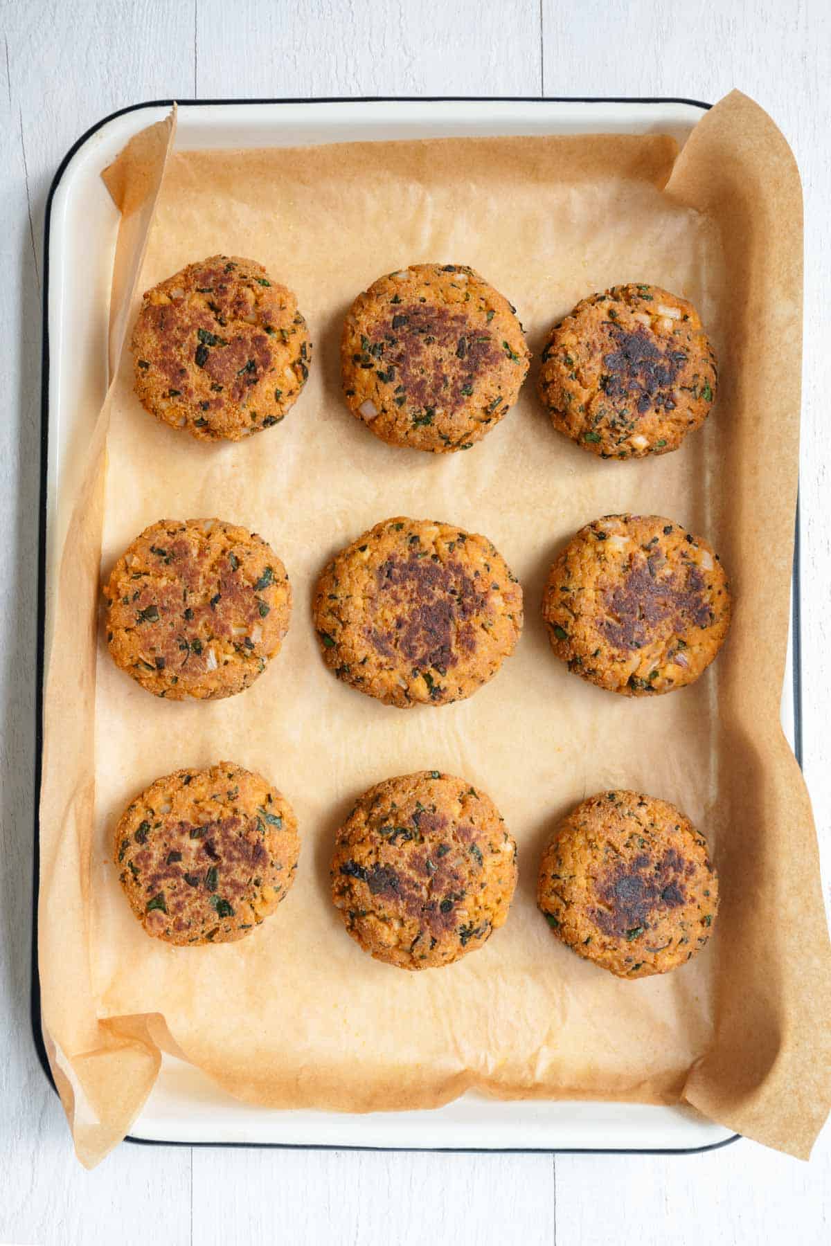 Golden brown, baked gluten-free tofu burgers, on a baking sheet.