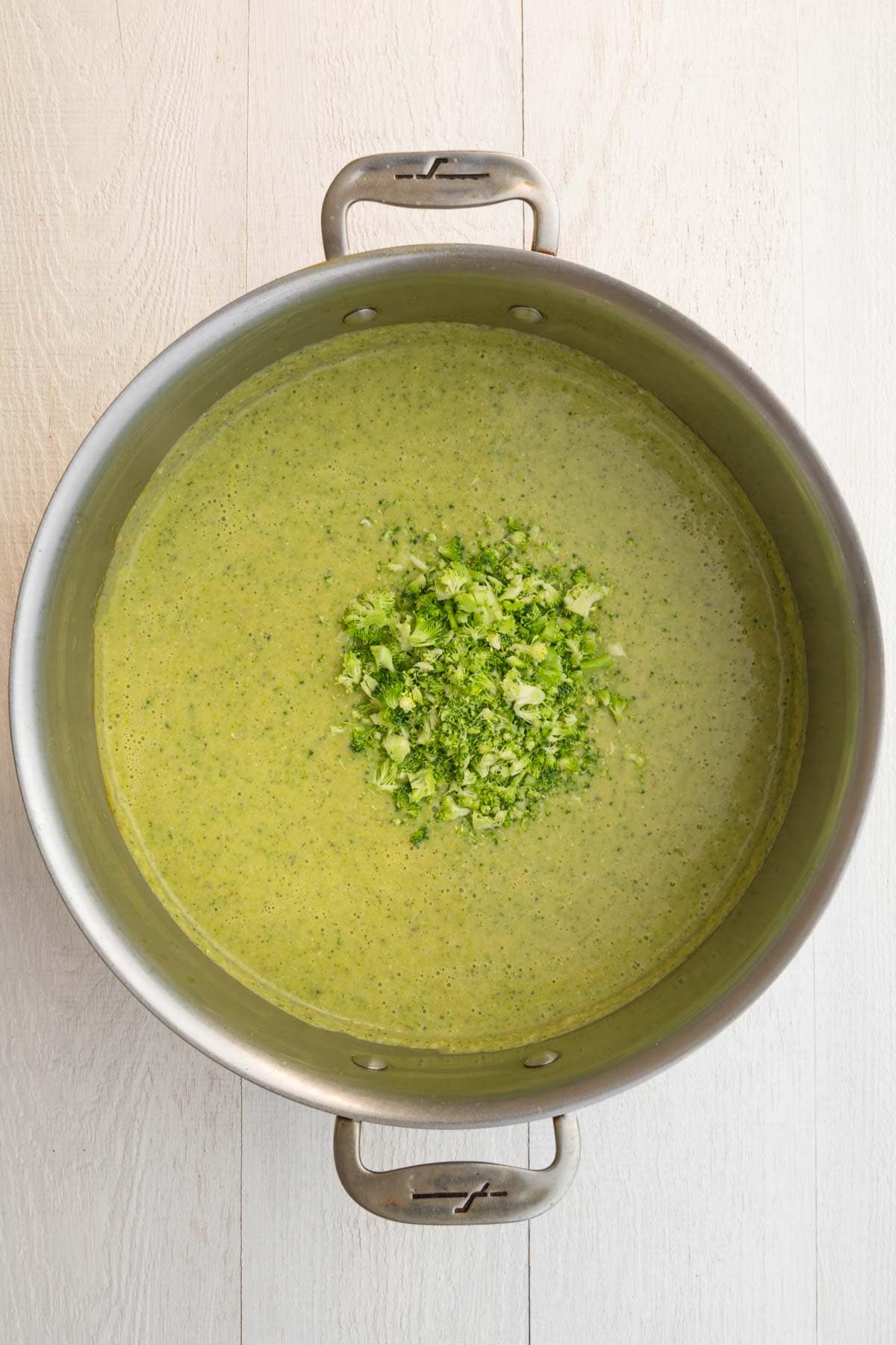 Vegan broccoli soup cooking with chopped broccoli florets.
