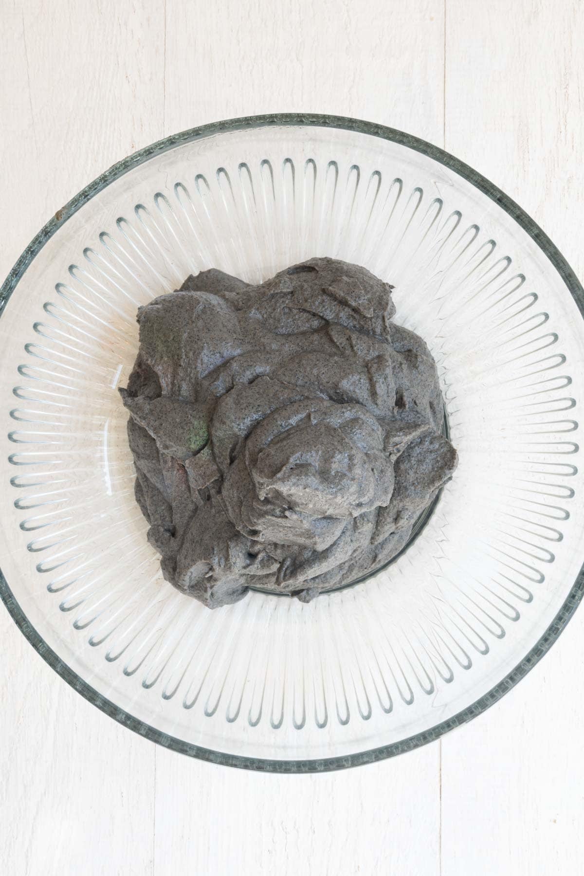 Black creamy batter in a large glass bowl.