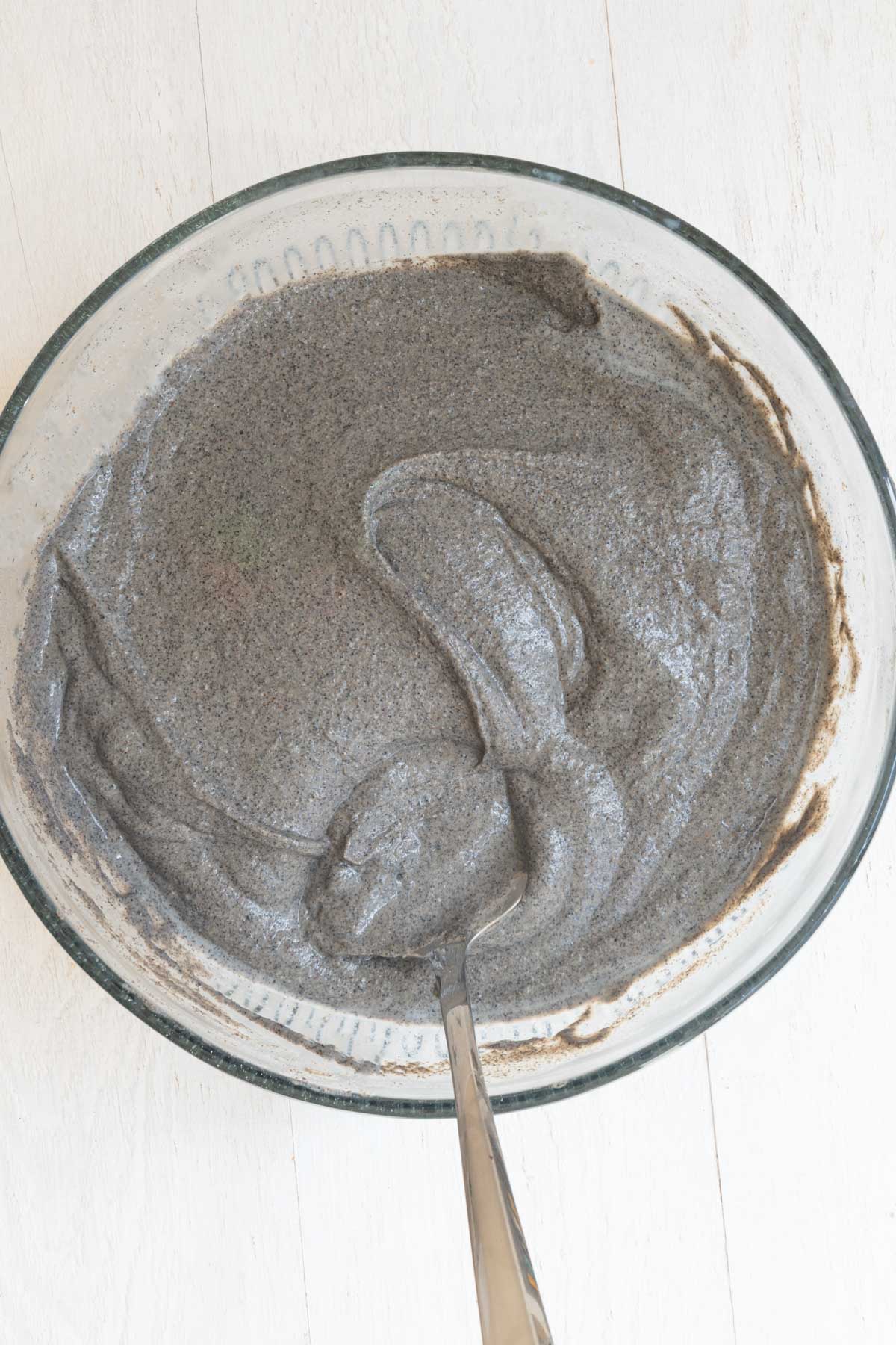Black creamy batter in a large glass bowl.