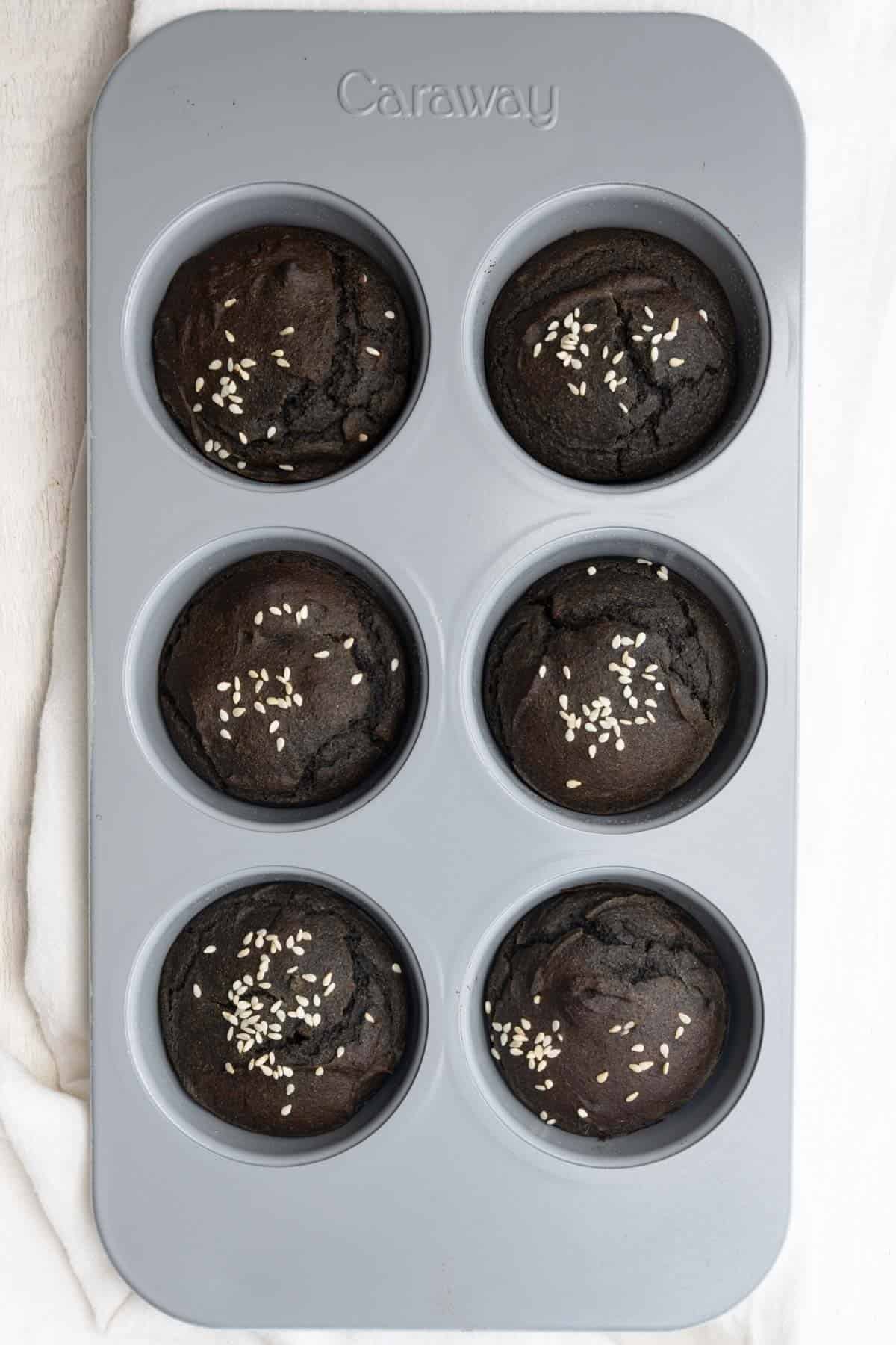 Black sesame date cakes in a muffin tin.