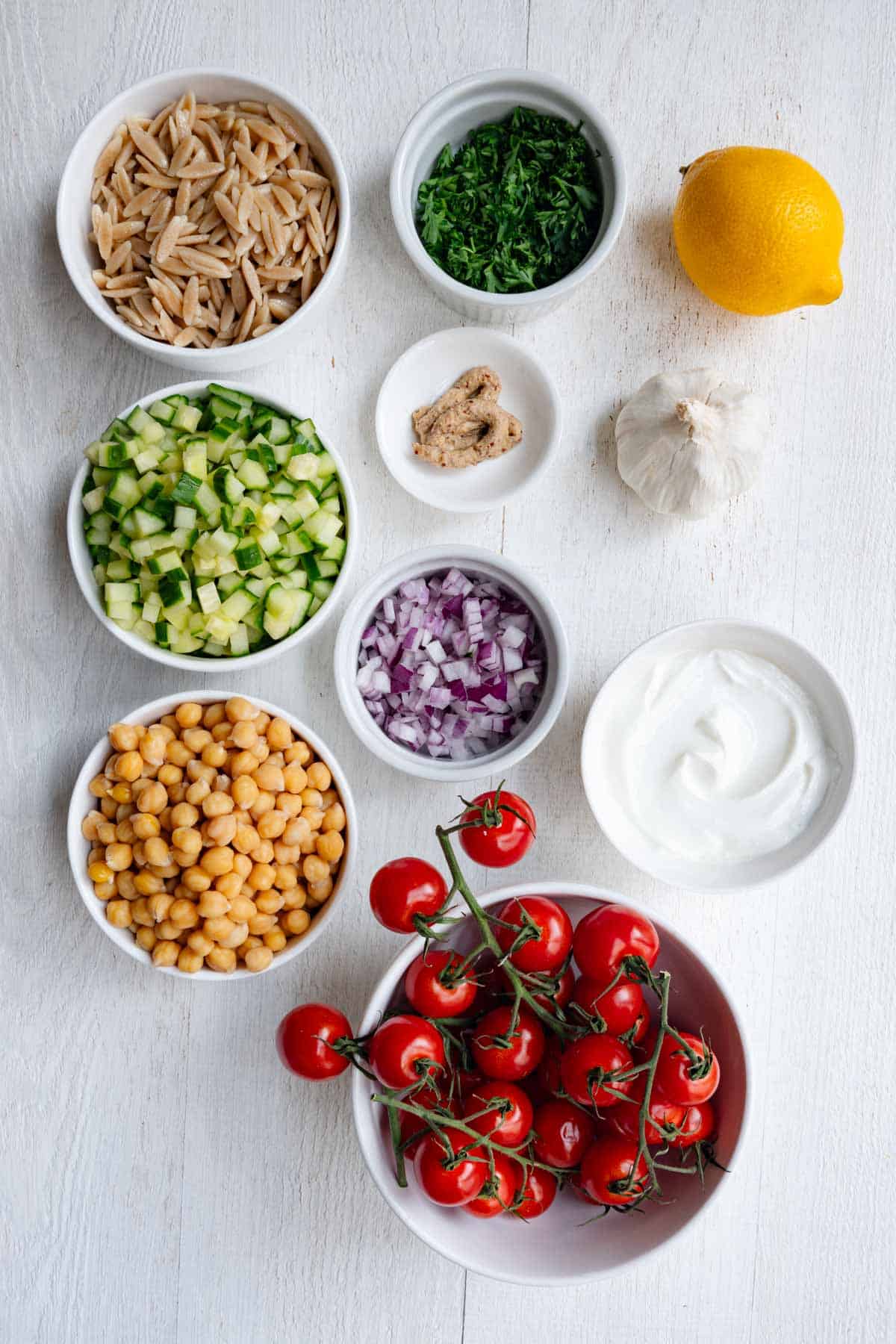 Chopped mint, red onion, cucumber, dill, and parsley, with chickpeas, orzo, tomatoes, yogurt, mustard, lemon, and garlic.