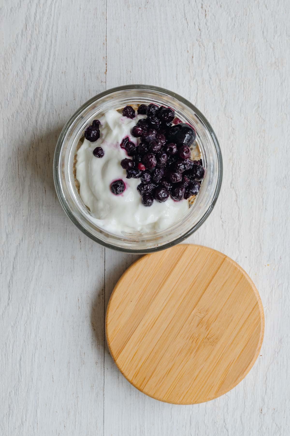 Healthy homemade muesli with ground flaxseeds, hemp hearts, dried tart cherries, prunes, oat bran, rolled oats, chia seeds, and hemp hearts topped with yogurt and berries.