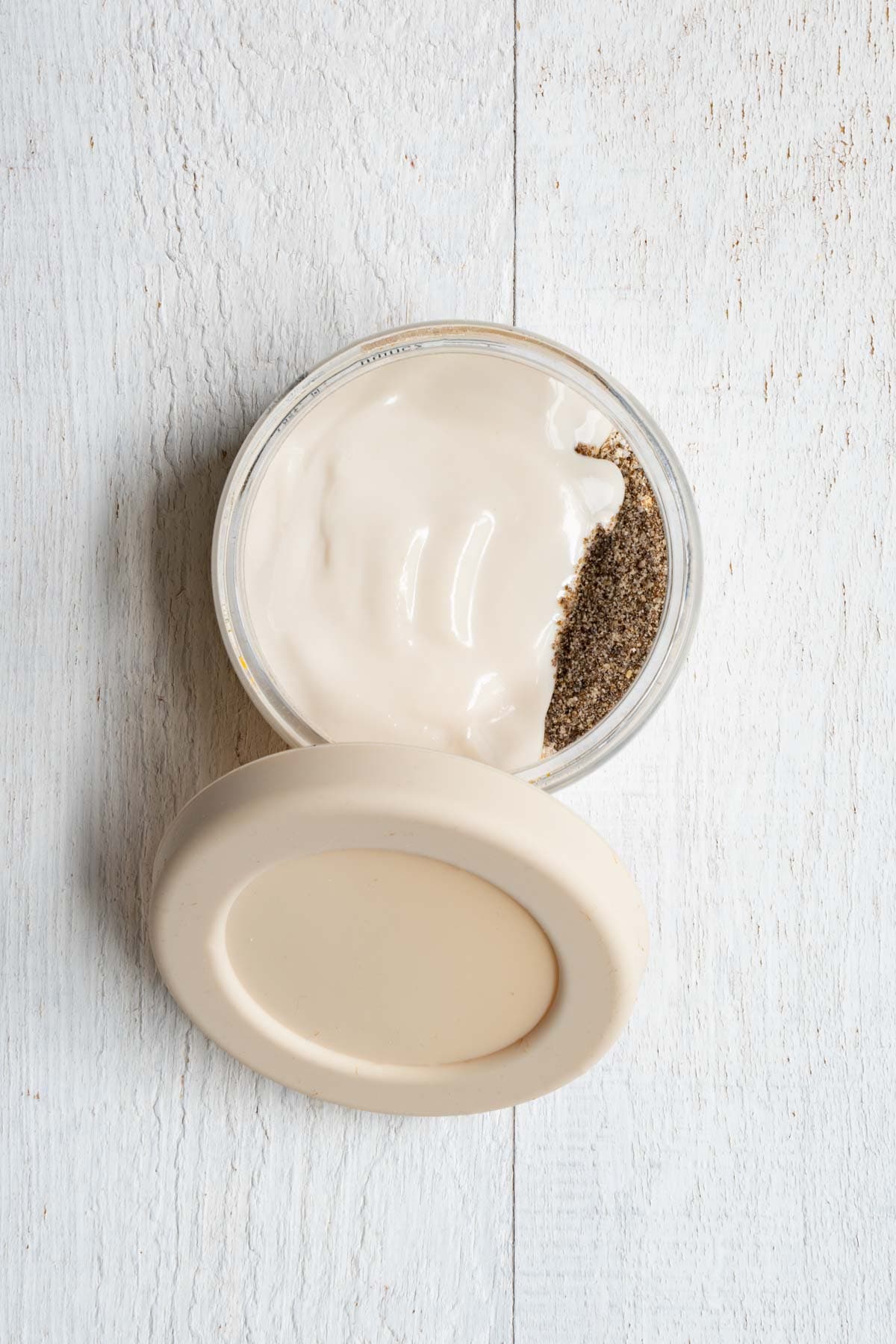 Rolled oats, oat bran, ground chia seeds, and Greek yogurt in a glass container.