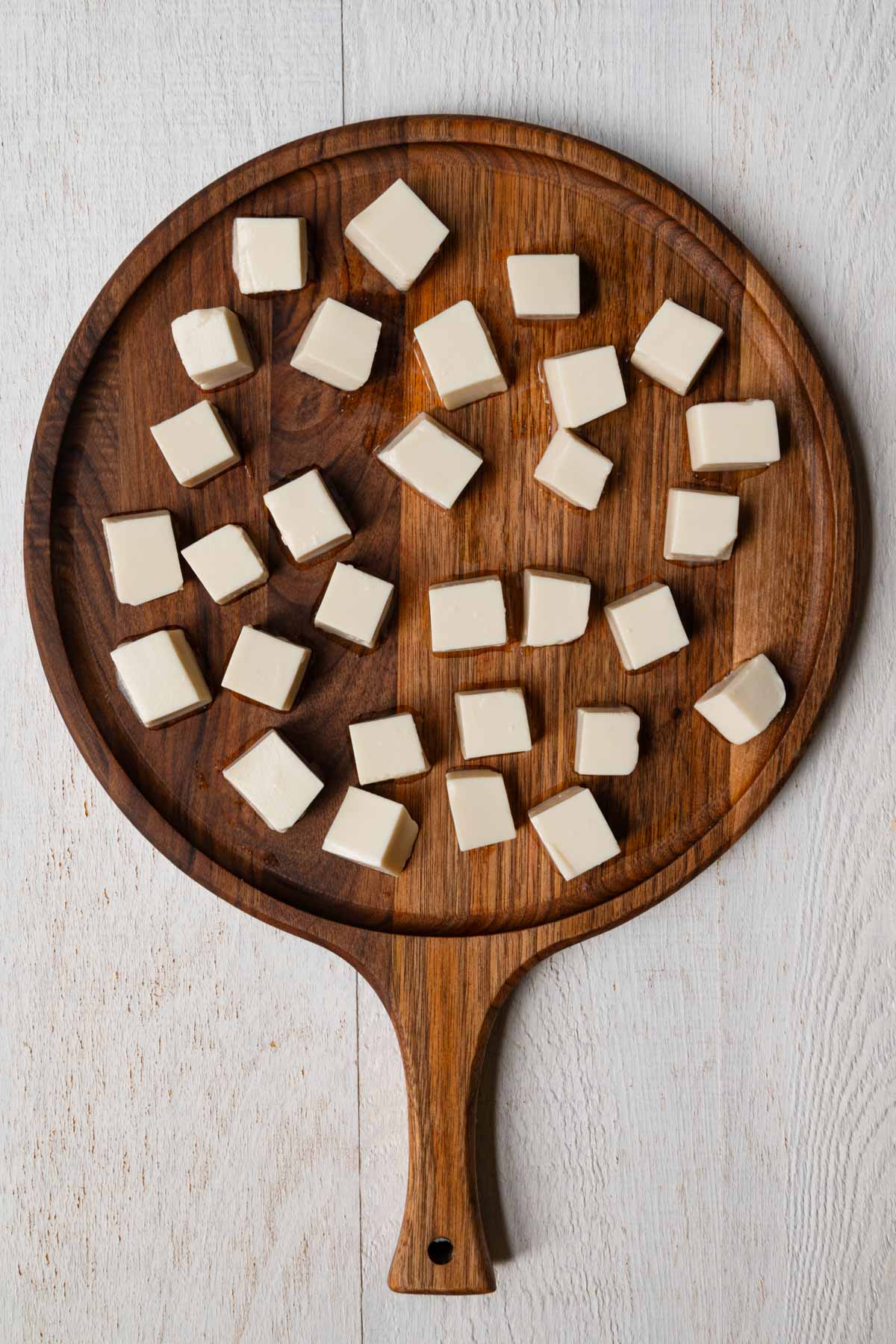 Cubed silken tofu on a cutting board.