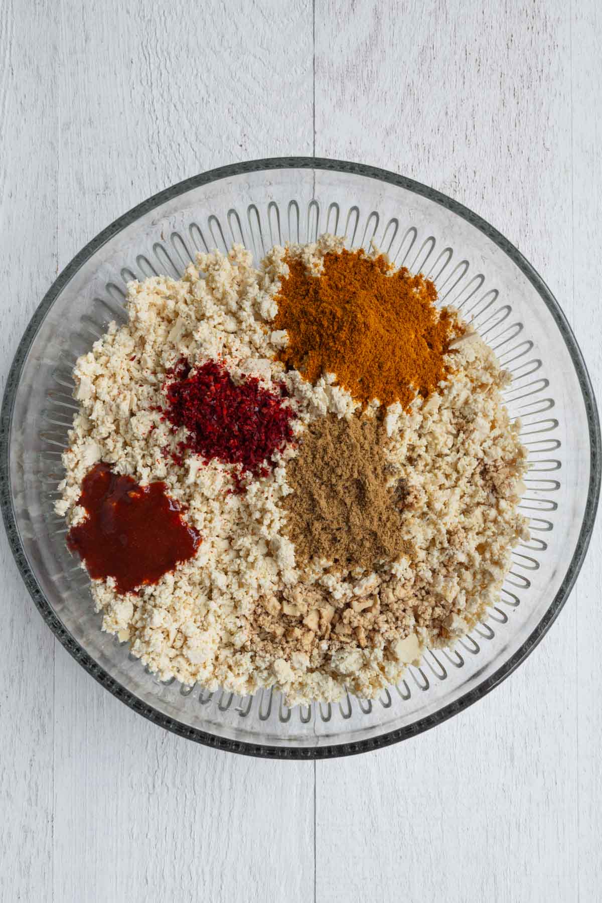 Crumbled tofu, cumin, curry powder, sriracha, tamari, rice vinegar, gochugaru, and black pepper.