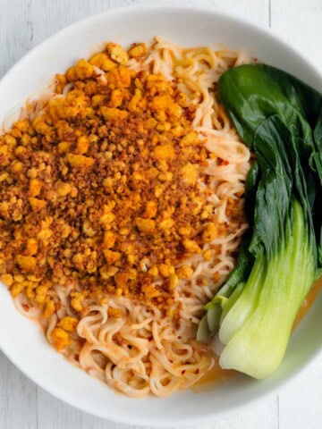Tofu Peanut Noodles with baby bok choy in a white bowl.