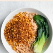 Tofu Peanut Noodles with baby bok choy in a white bowl.