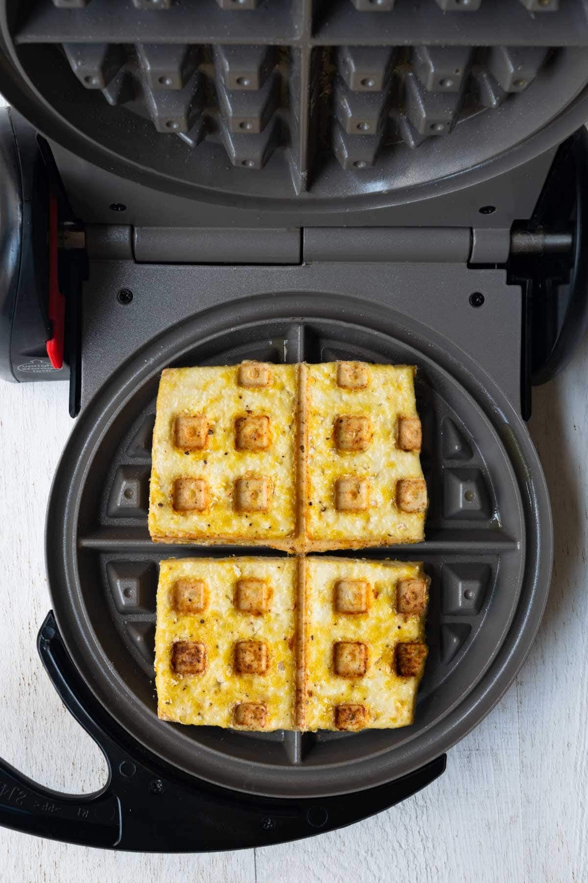 Tofu waffle in a waffle maker.