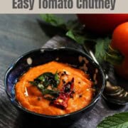 Tomato chutney in a black bowl.