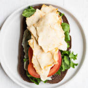 Vegan deli meat on an open face sandwich.