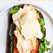 Vegan deli meat on an open face sandwich.