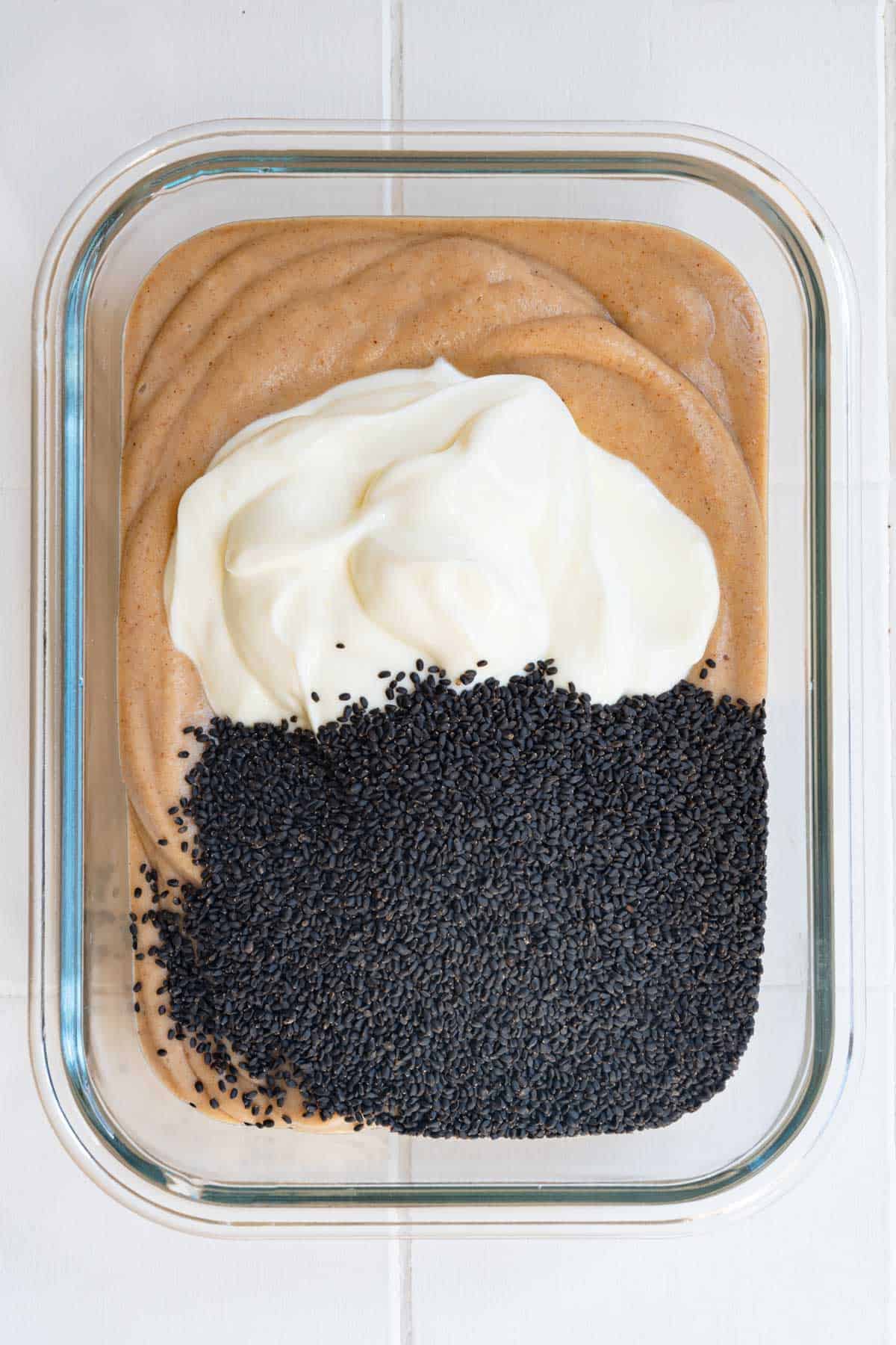 Blended banana milk mixture topped with yogurt and chia seeds in a glass dish.