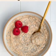 Banana chia seed porridge in a bowl topped with raspberries.