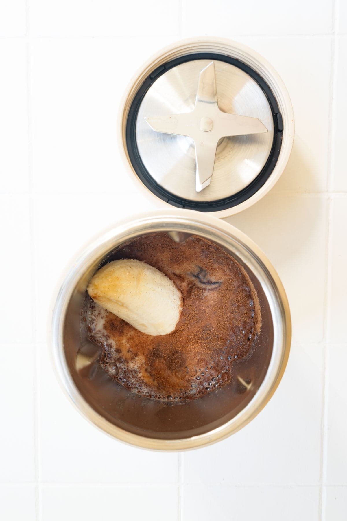 Banana, cinnamon, vanilla, cooked red lentils, nondairy milk, and dates in the canister of a blender.