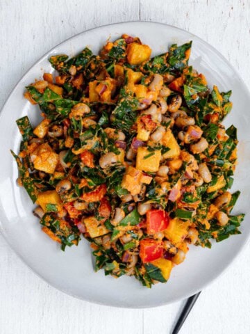 Black eyed peas salad on a white plate and a black fork.
