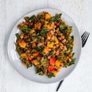 Black eyed peas salad on a white plate with a black fork.