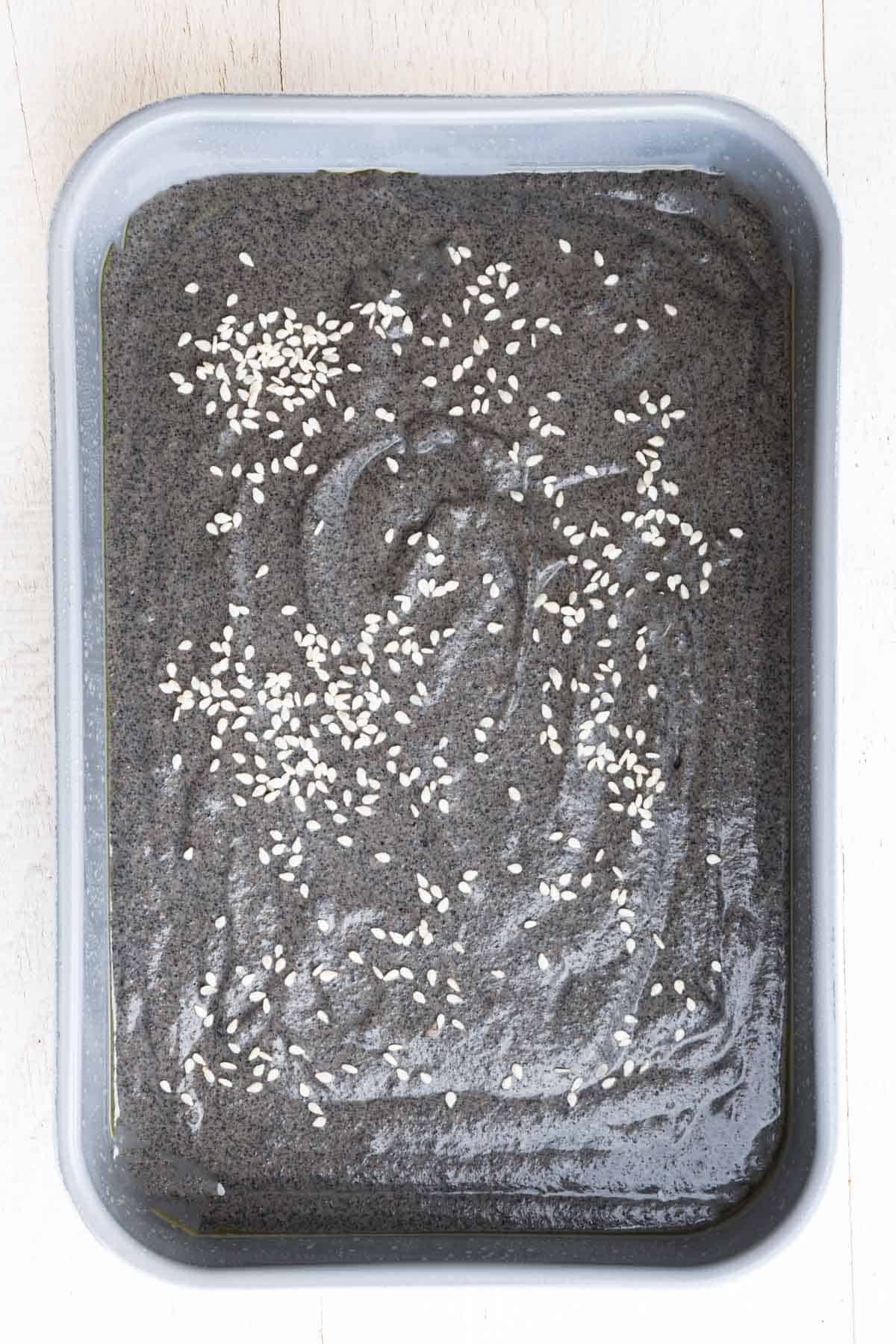 Black sesame date cake batter in a loaf pan.