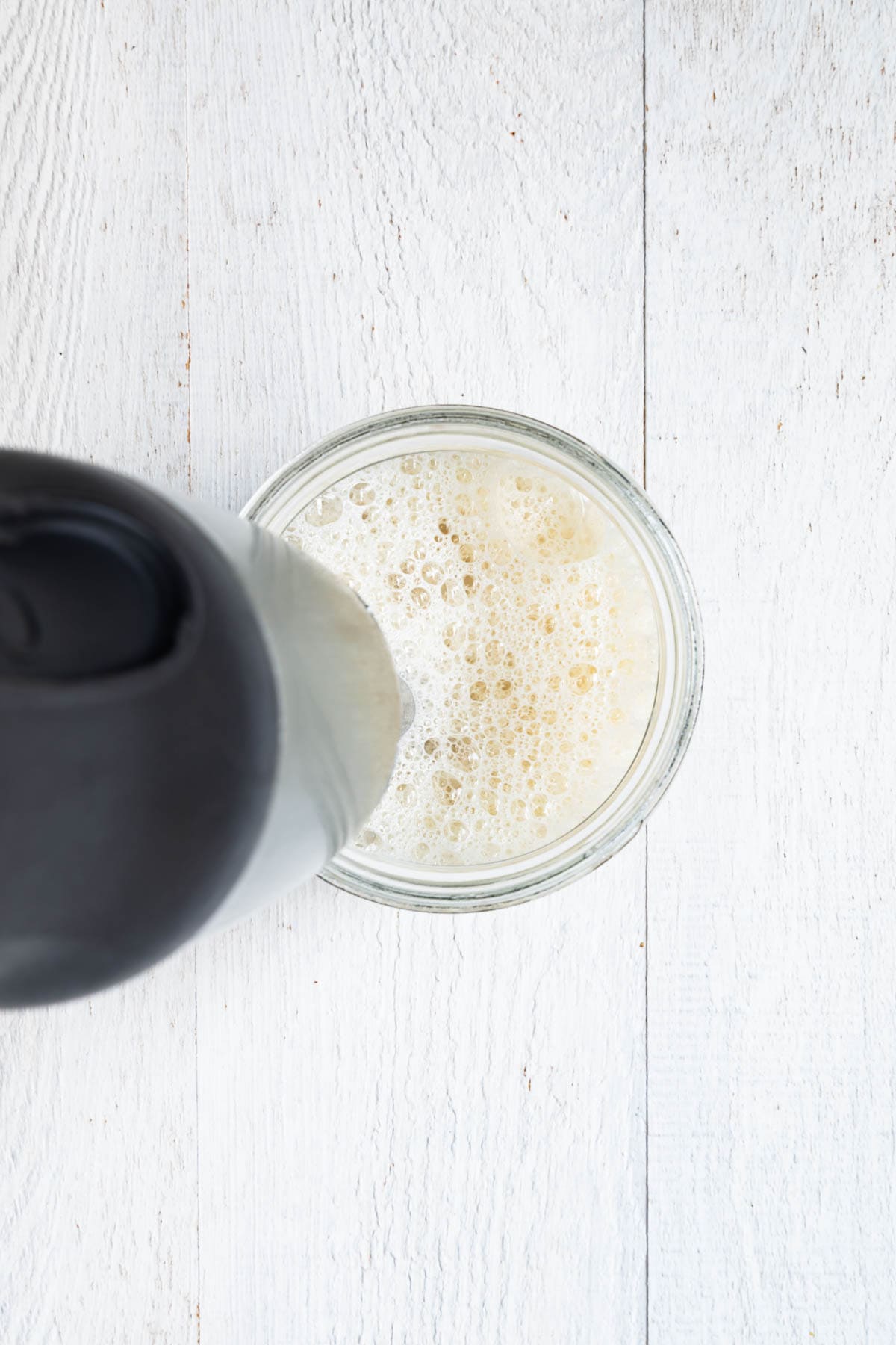 Dates being blended in nondairy milk with an immersion blender.