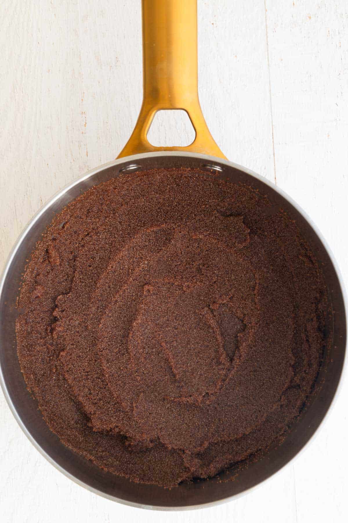 Cooked teff in a stainless steel saucepan.