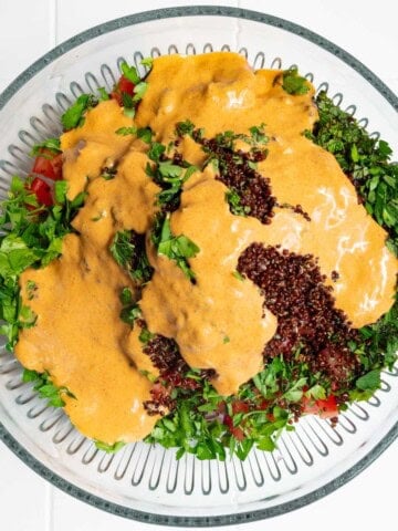 Pouring harissa dressing onto salad.