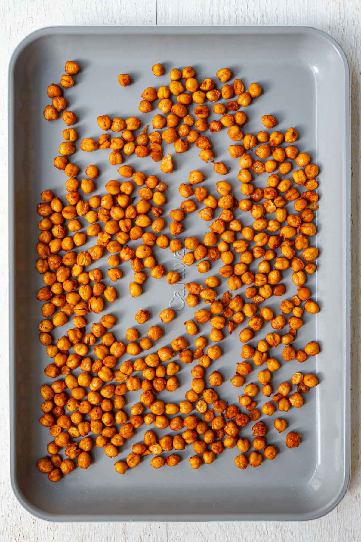 Crispy roasted harissa chickpeas on a baking sheet.