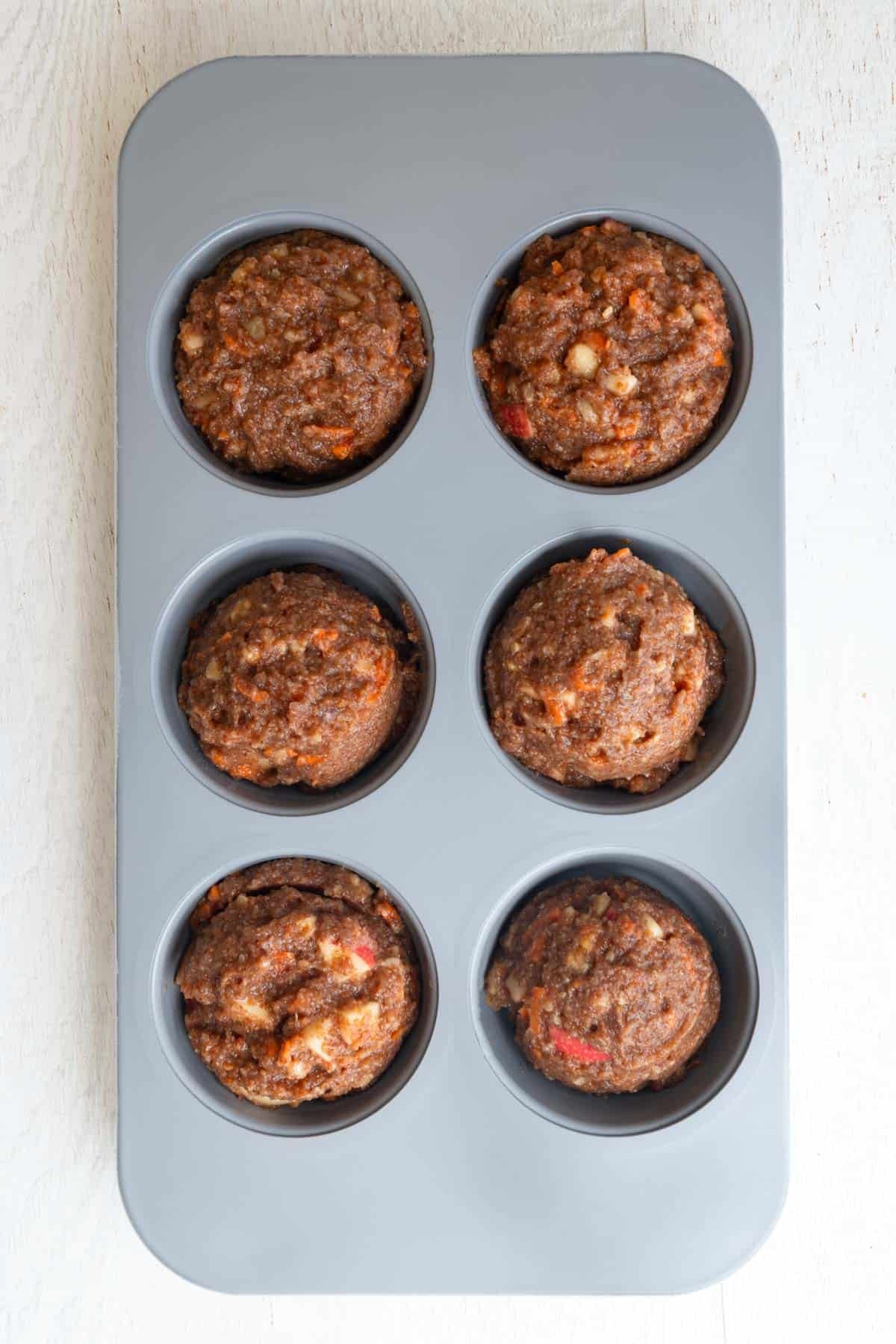 Gluten-free flourless muffin batter in a ceramic muffin tin.