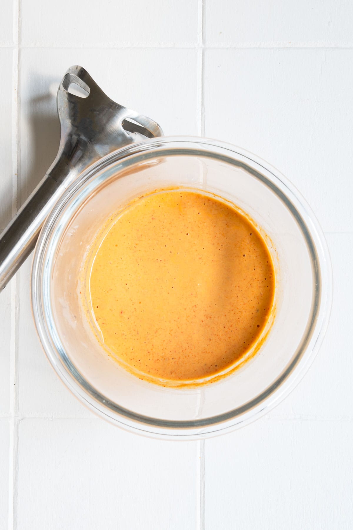 Creamy harissa sauce or dressing in a glass jar.