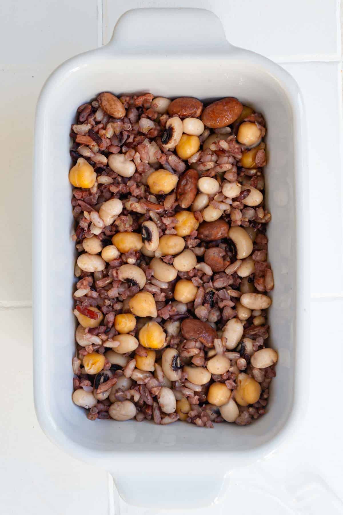 Seven grain rice mix with garbanzos, navy beans, black eyed peas, and pinto beans in a white dish.