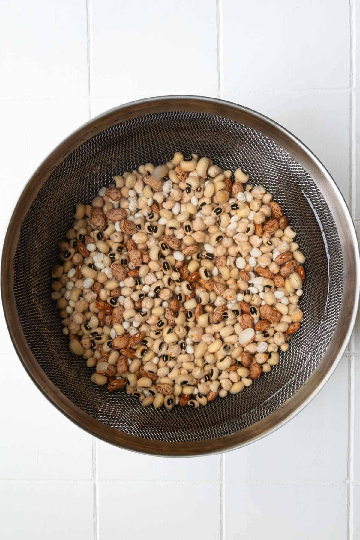 Drained soaked beans in a sieve.