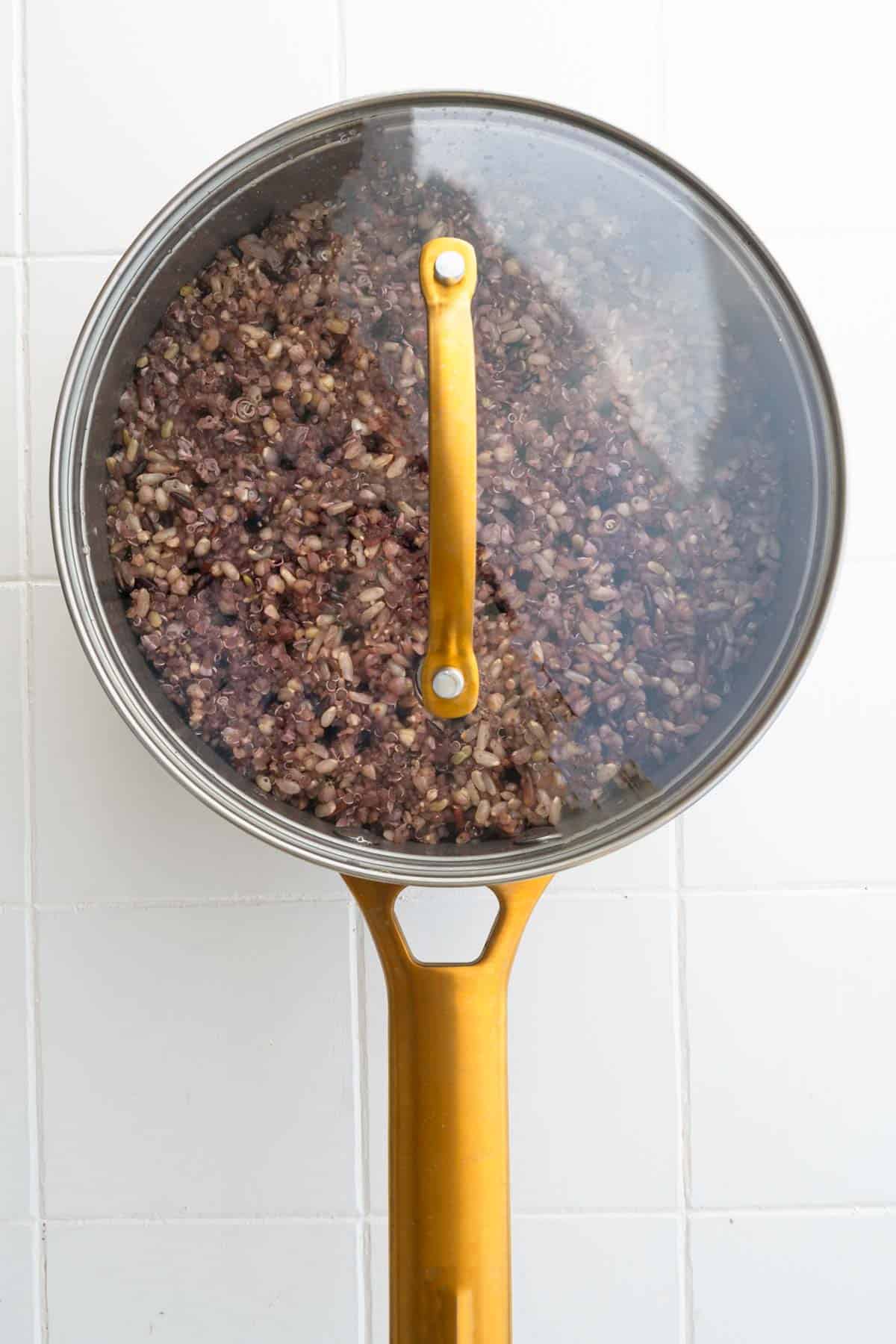 Cooked seven grain mix with rice in a covered saucepan.