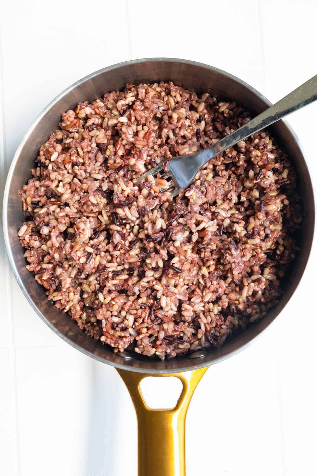 Seven grain rice mix fluffed with a fork.