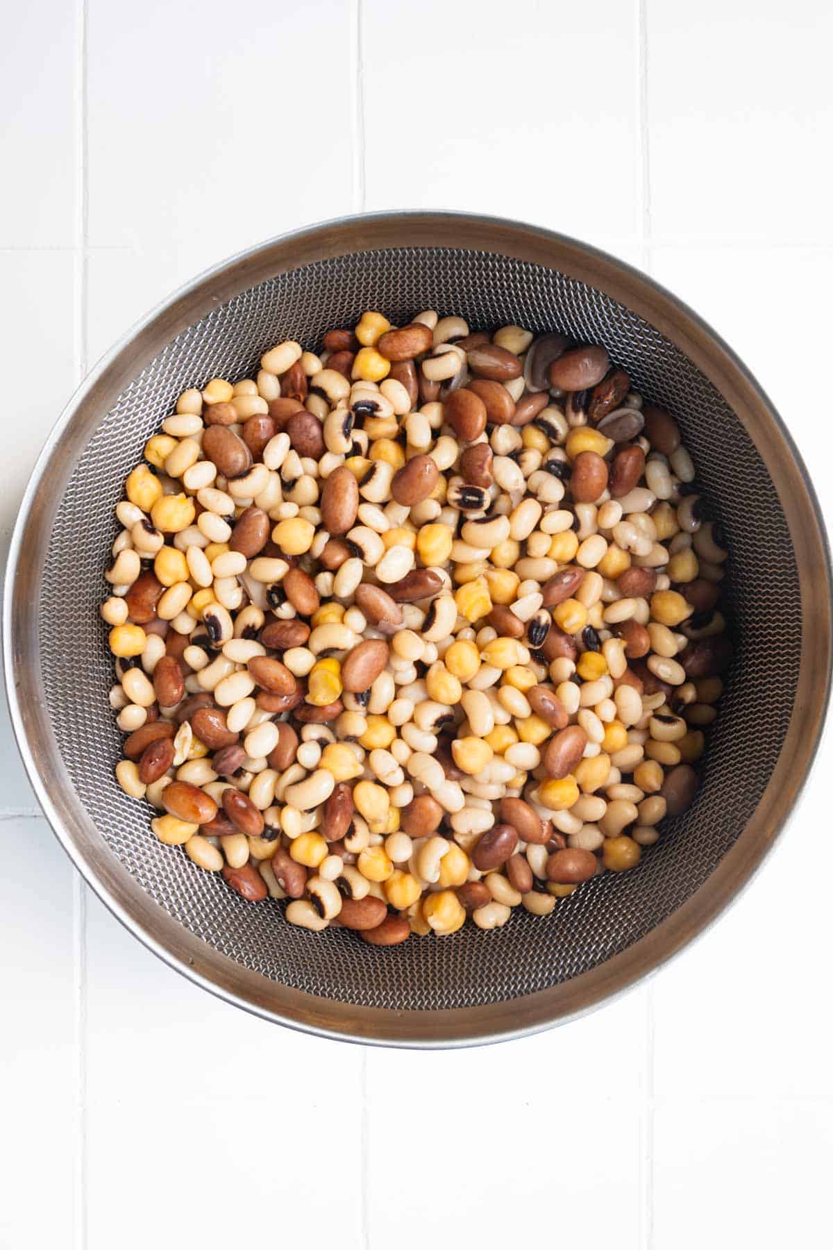 Drained cooked beans in a sieve.