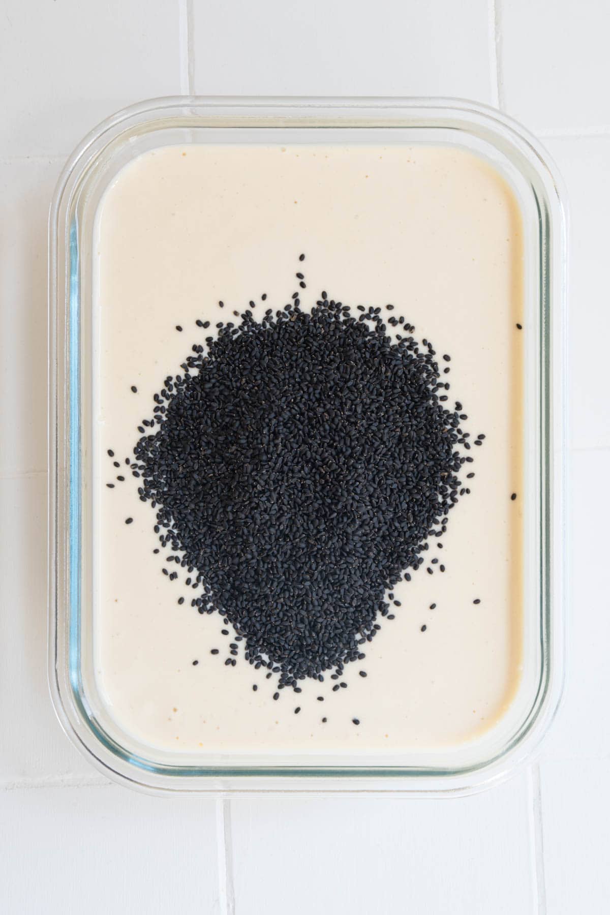 Blended savory miso mixture with basil seeds in a container.