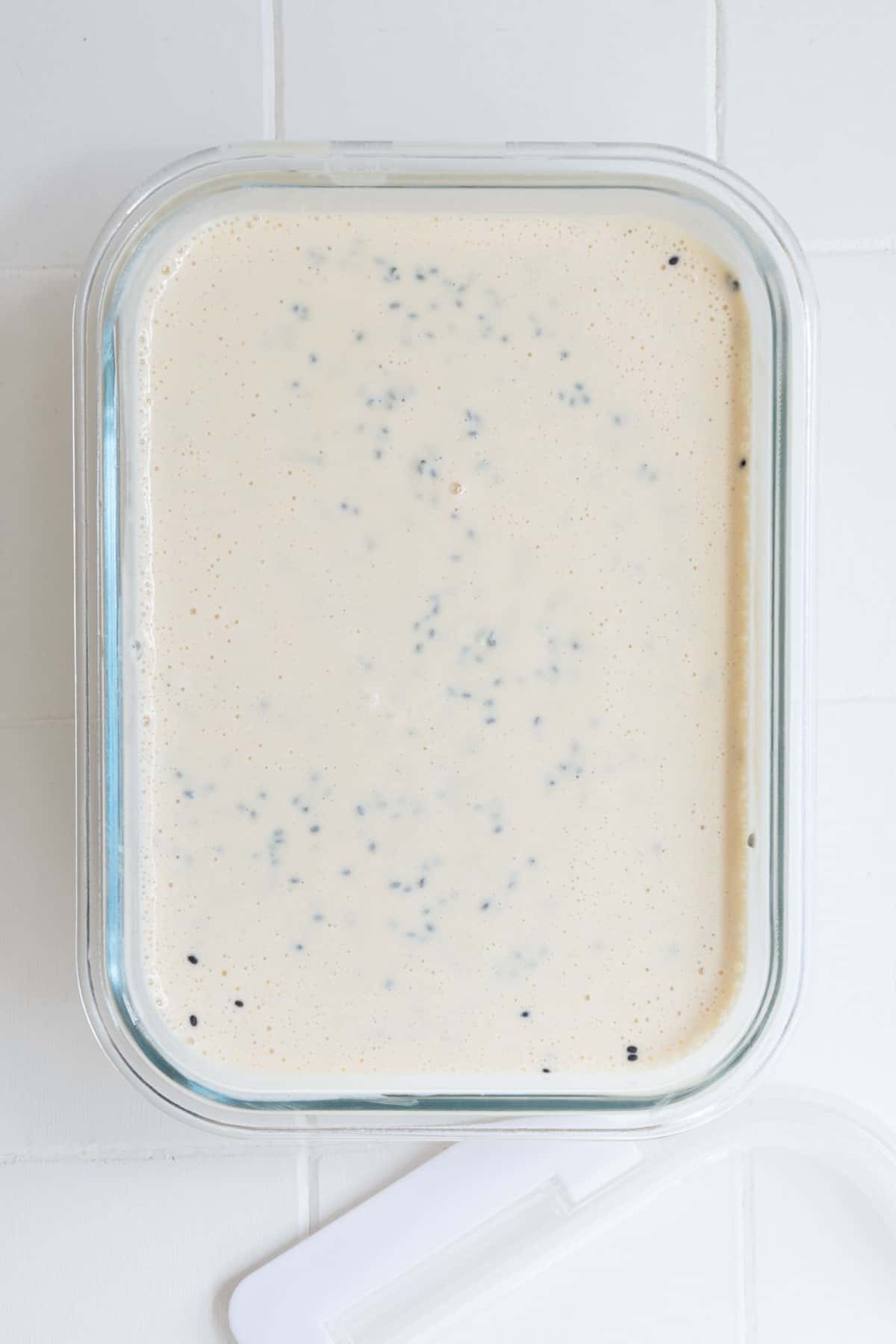 Chia seeds, yogurt, and blended ingredients in a glass conatiner.