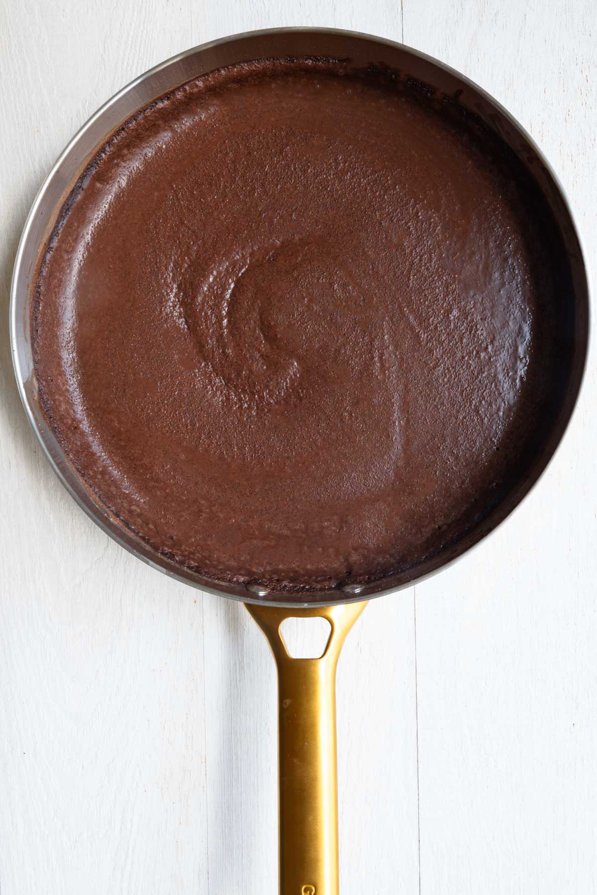 Cooking Chocolate Teff Porridge in a large skillet.
