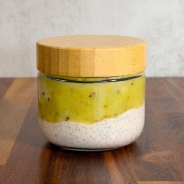 Basil seeds pudding in a glass container topped with kiwi.