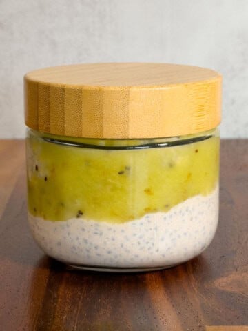 Basil seeds pudding in a glass container topped with kiwi.