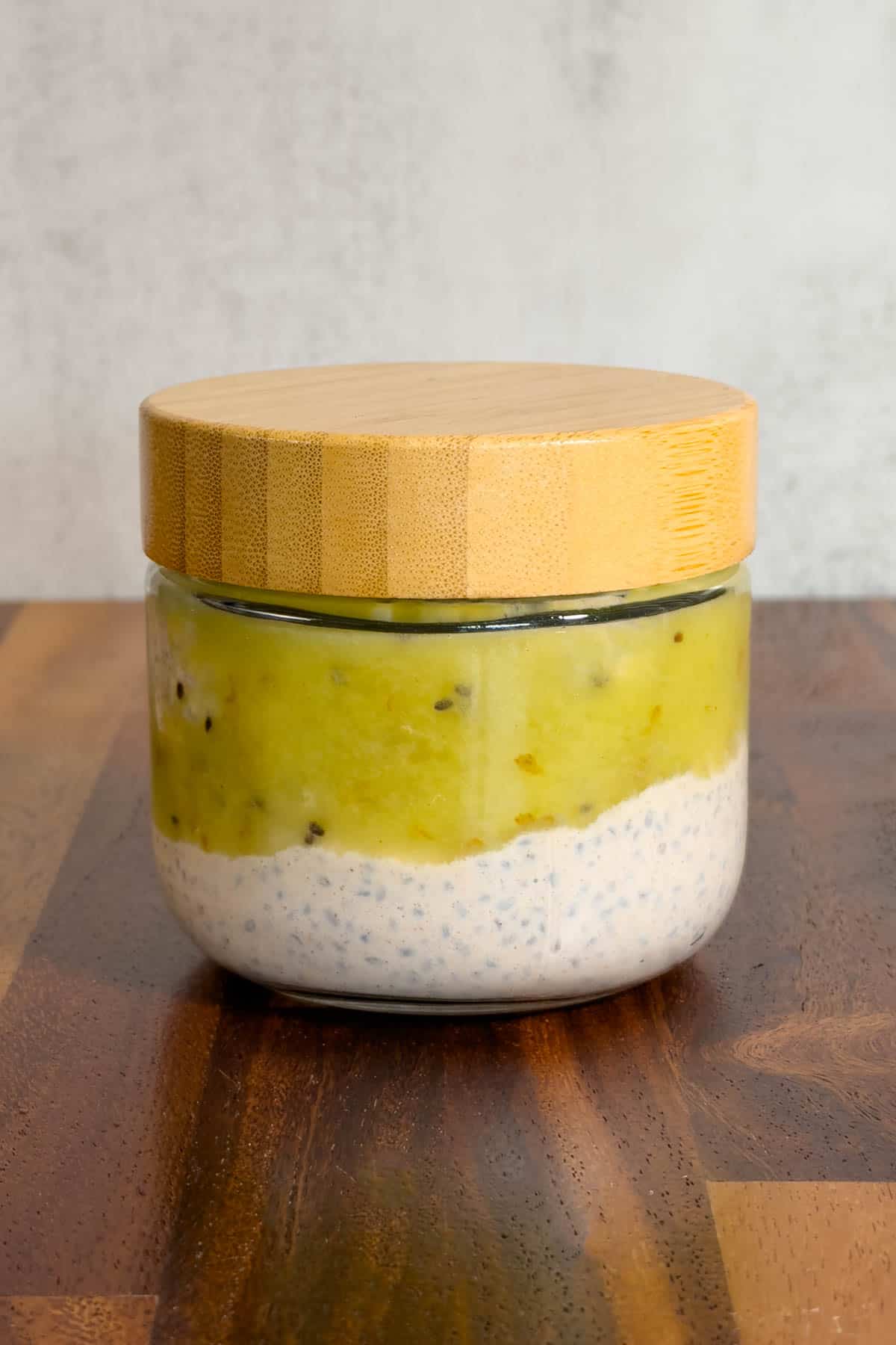 Basil seeds pudding in a glass container topped with kiwi.