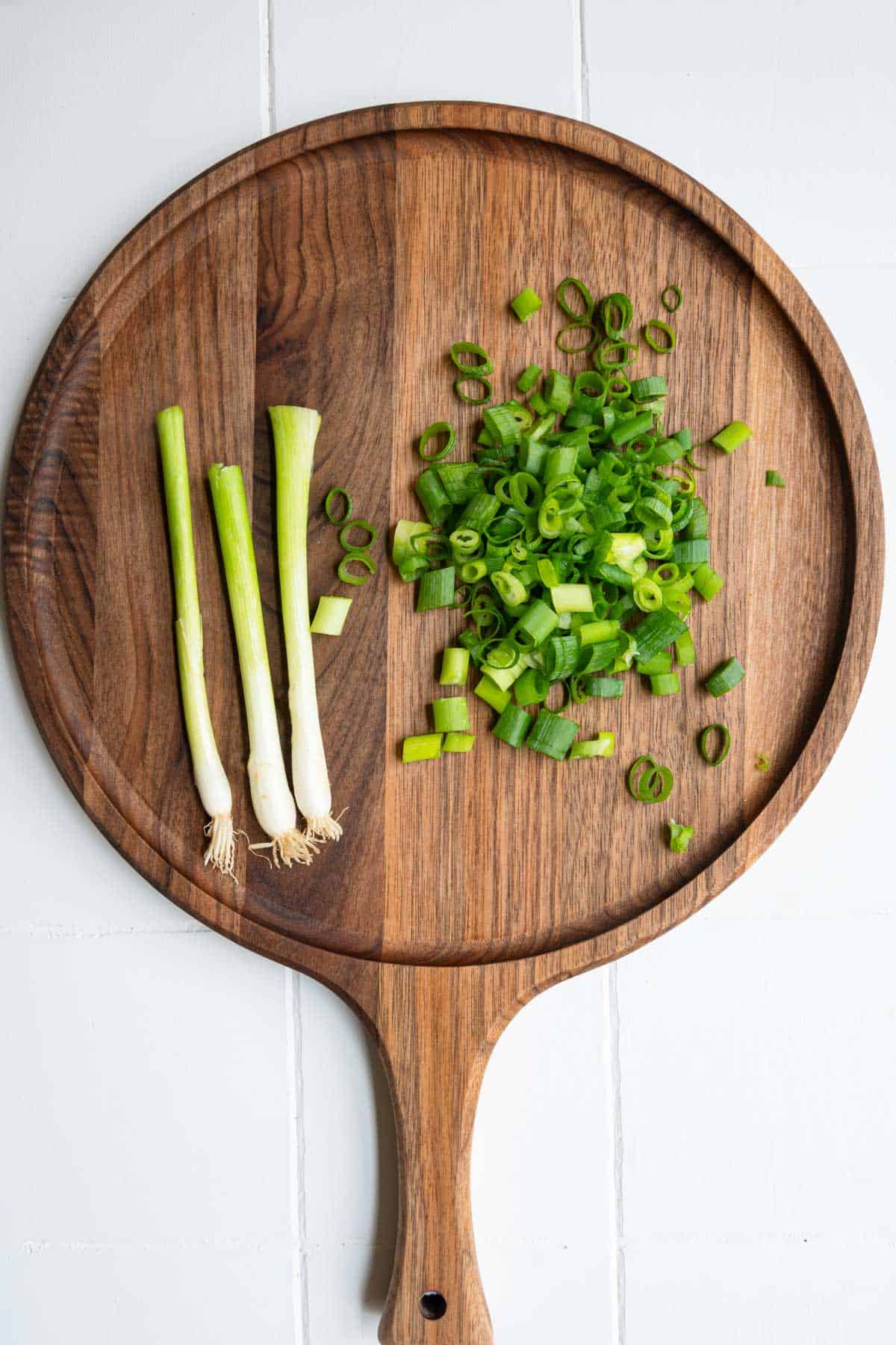 Sliced green onion on a cutting board.