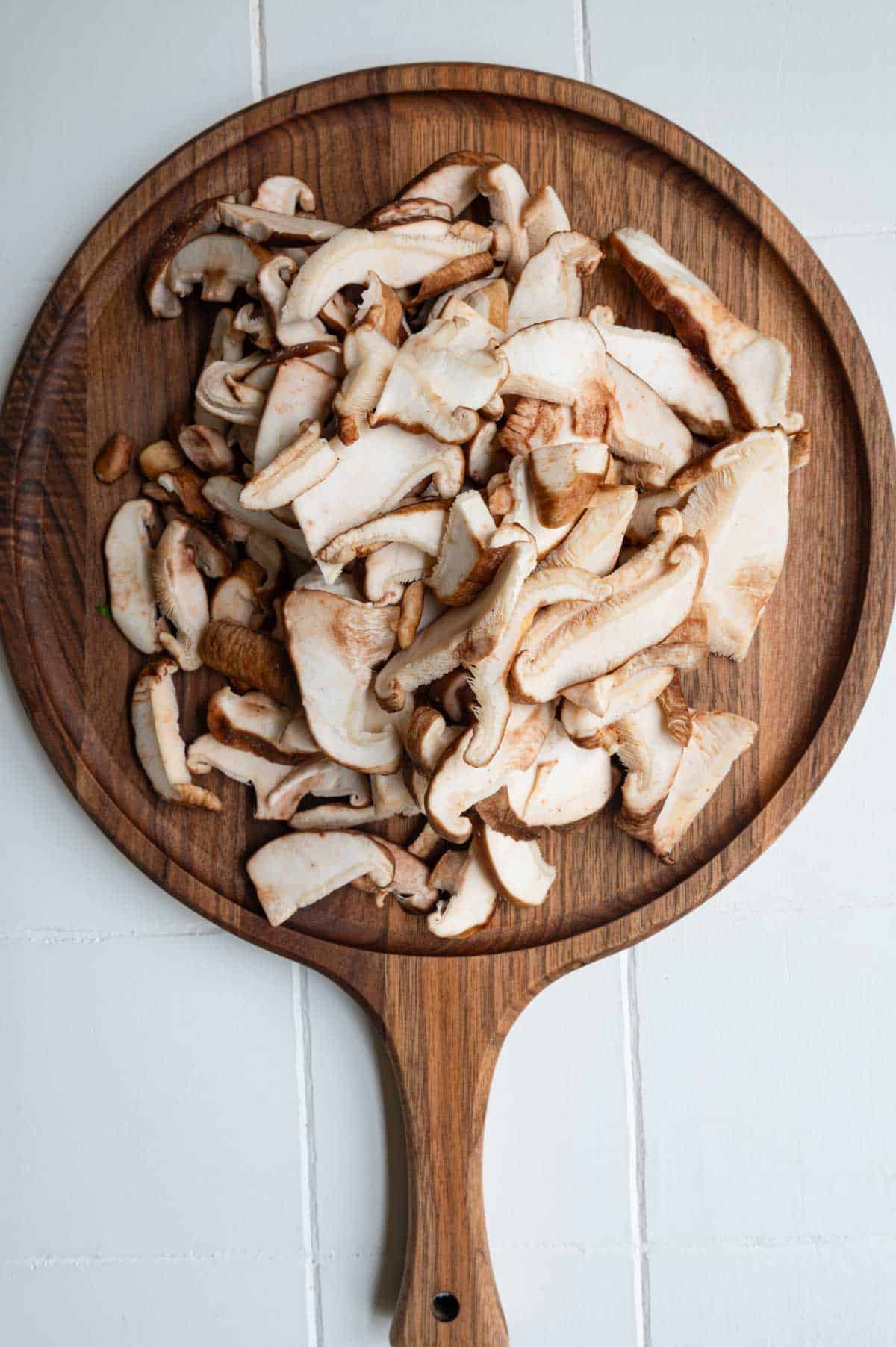 Sliced shiitake mushroom on a cutting board.